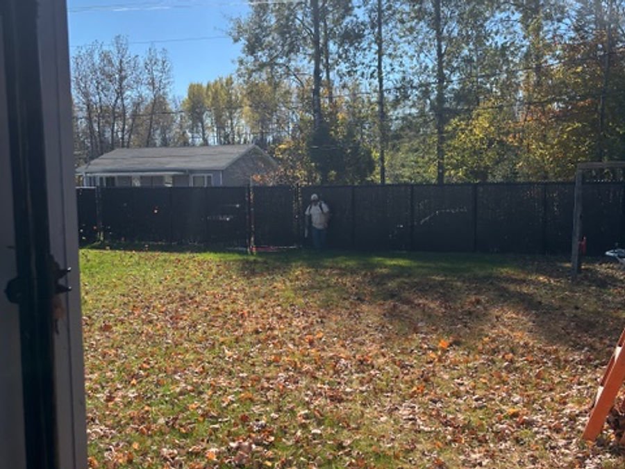 Mowed lawn bordered by a fence and a flower bed