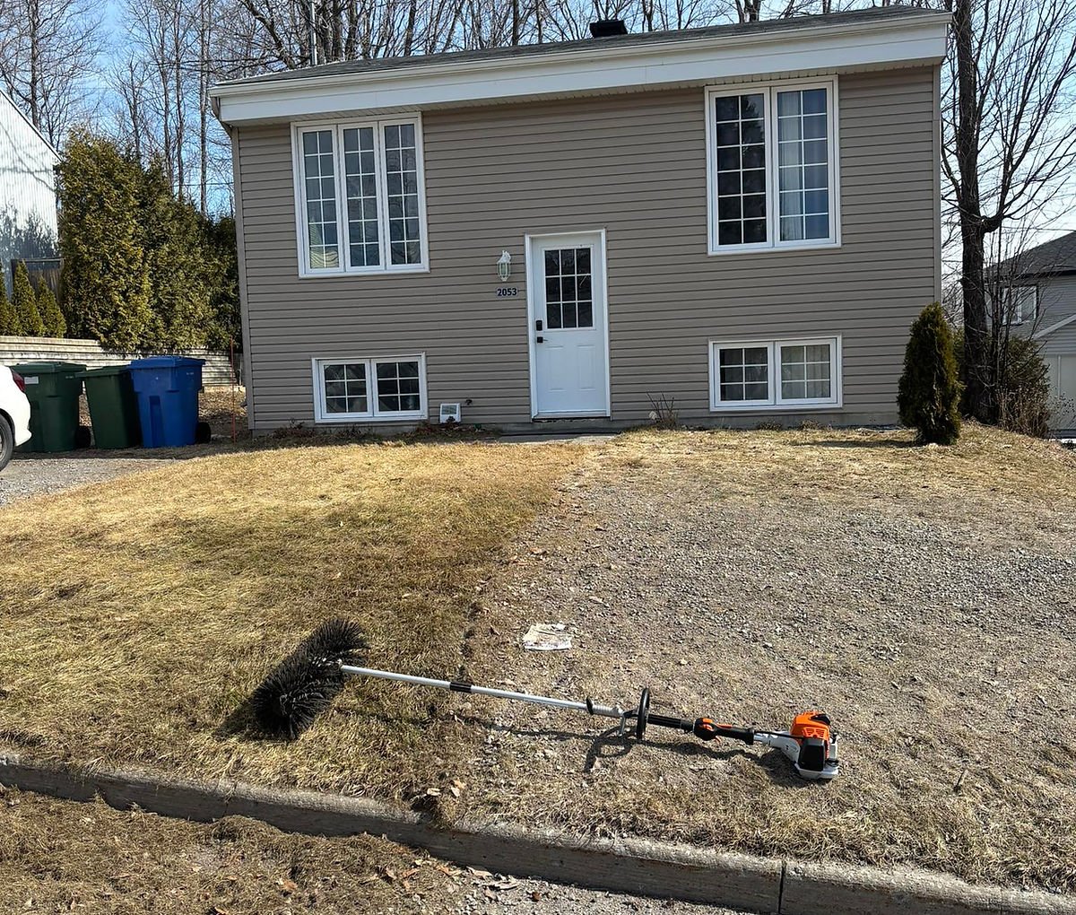 Spring property cleanup in front of a home in the Quebec City area