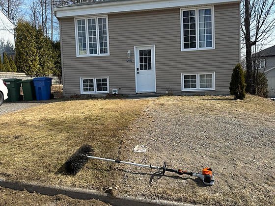Spring property cleanup in front of a home in the Quebec City area