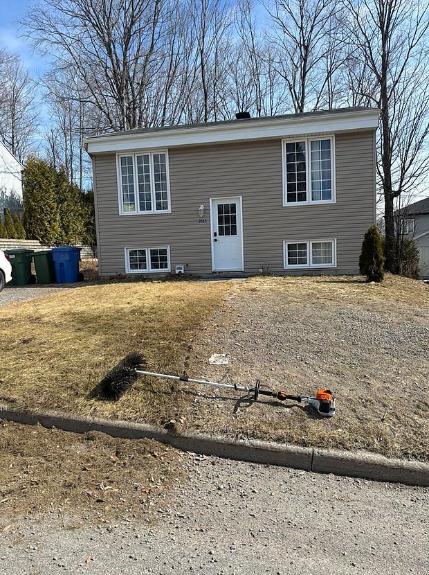 Printemps : Terrain nettoyé au printemps devant une maison résidentielle de la région de Québec